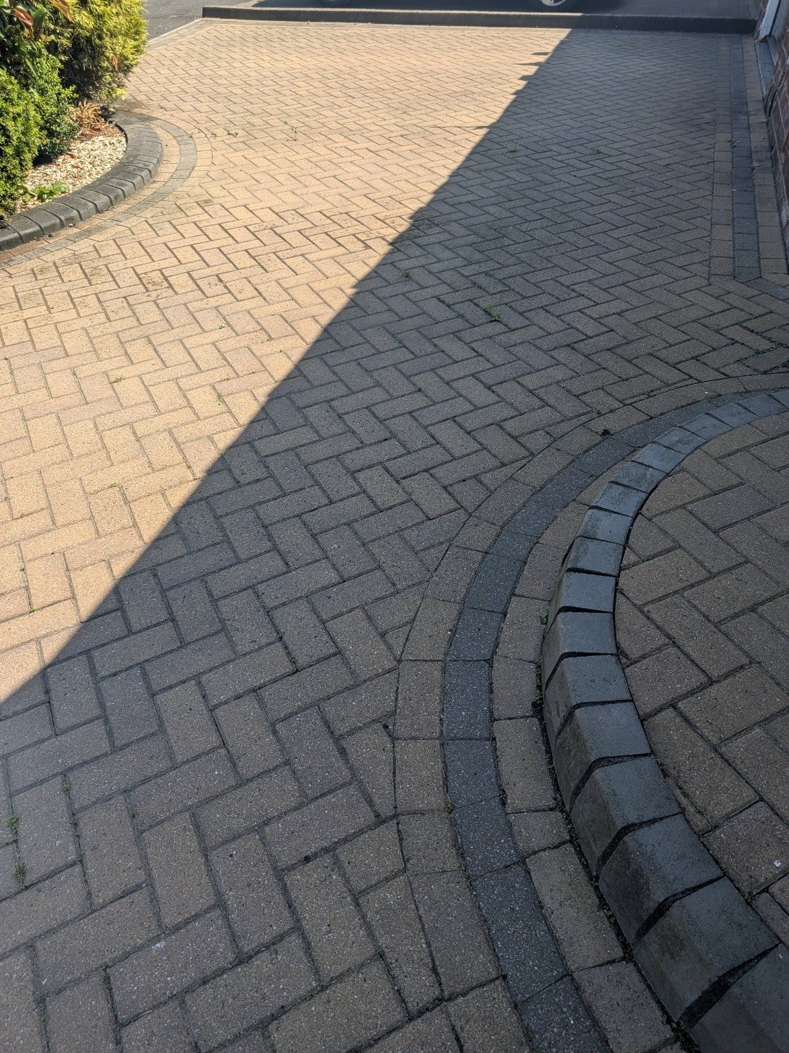 Curved block paving border before cleaning